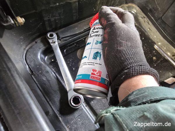 Lösen der vorderen, inneren Schrauben am Batteriekasten