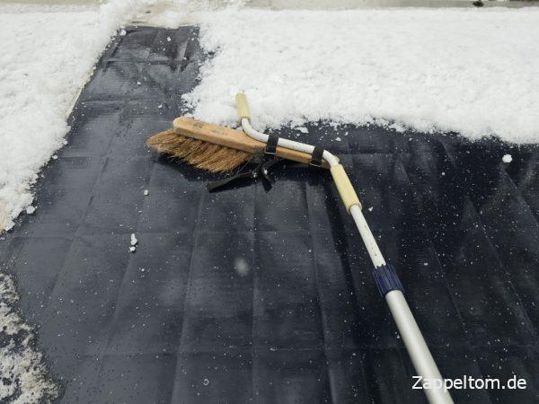 Schnee von der Solaranlage auf dem Wohnmobil kehren