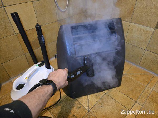 Innere Motorabdeckung mit dem Dampfreiniger sauber machen