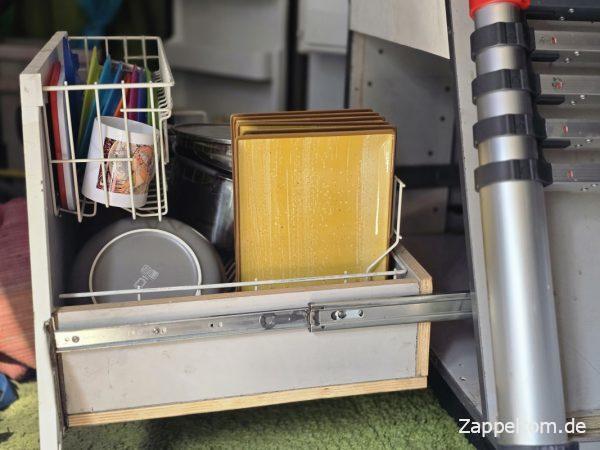 Küchenauszug mit Keramikgeschirr im Wohnmobil