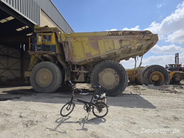 Minifahrrad und Riesenmuldenkipper in Metlaoui