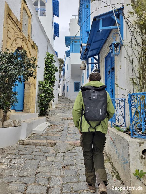 Mann und Ortlieb-Rucksack trotzen dem Wetter in Sidi Bou Saïd Mann und Ortlieb-Rucksack trotzen dem Wetter in Sidi Bou Saïd